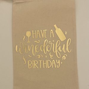 Handmade wine bag with the words “Have a winederful birthday” in gold. Around the words is a wine glass, bottle and some gold sparkles.